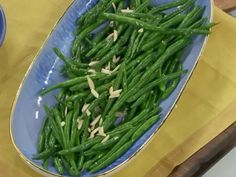 green beans are in a blue bowl on a table