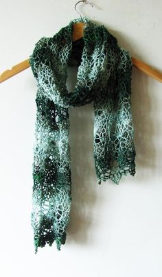 a green scarf hanging on a wooden hanger