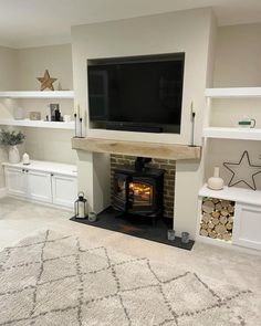 a living room with a fireplace, tv and shelves on either side of the fire place