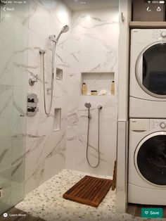 a washer and dryer sitting in a bathroom next to a walk in shower