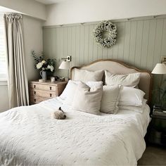 a white bed sitting in a bedroom next to a window