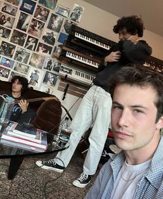 a man sitting in front of a glass table next to a woman standing behind him