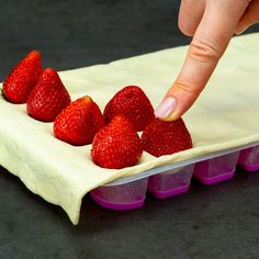 someone is placing strawberries on top of the cake