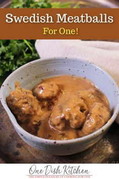 swedish meatballs with gravy in a white bowl on top of a table