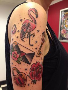 a flamingo tattoo on the left arm and shoulder, with other tattoos around it