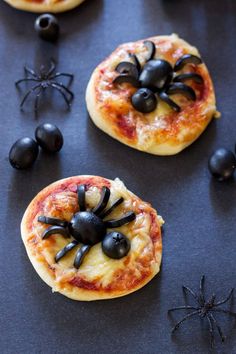 small pizzas with black spider decorations on them