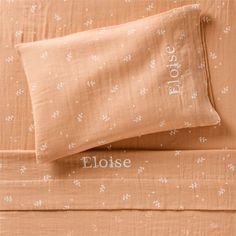 an orange bed spread with white flowers on it and the words floise written in cursive font