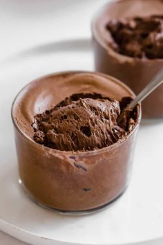 chocolate mousse in a glass bowl on a white plate with the words, the cremest easy chocolate mousse