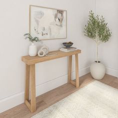 a wooden table sitting next to a white vase on top of a hard wood floor