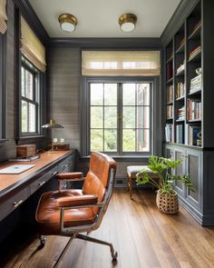 a home office with leather chairs and bookshelves