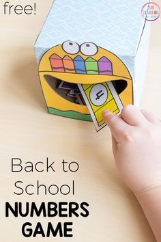 a child's hand is opening a box with numbers on it and the words back to school