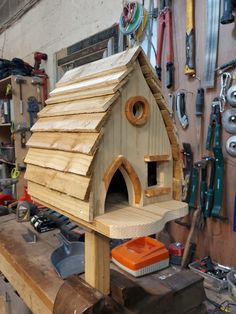 a birdhouse made out of wood in a workshop