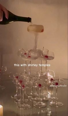 someone pouring wine into several glasses on a table with candles in the background and text that reads, this with barley temples