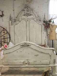 an old white bed in a room with brick walls and flooring, along with other antique furniture