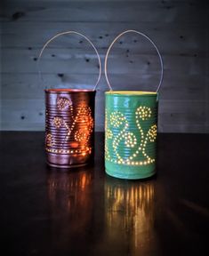 two tin can lights sitting on top of a table