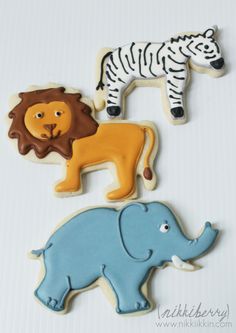 three decorated cookies in the shape of animals