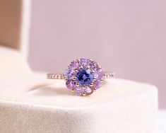 "✨ITEM DETAILS Metal: 14K Rose Gold Weight: 3.94  Certificate: GEL Total Carat Weight:  2.26  Ring Size: 6 Note: Free sizing: 5-8   ✨ MAIN STONE Gemstone:  Tanzanite  Shape: Round Brilliant  Gemstone Amount:  1  Carat Weight:  0.75  Color:  Purplish-Blue  Clarity:  Transparent  Creation Method: Natural Commonly Treated    ACCENT STONE Gemstone:  Diamond  Shape: Round Brilliant  Gemstone Amount:  9  Carat Weight:  1.25  Color:  Pink  Clarity:  Transparent  Creation Method: Natural Commonly Treated    ACCENT STONE Gemstone:  Diamond  Shape: Round Brilliant  Gemstone Amount:  14  Carat Weight:  0.26  Color:  Light Pink-Natural Fancy Pink  Clarity:  SI1-I1  Creation Method: Natural   ✨RETURN & EXCHANGE: * No Hassle, Full refund or exchange within 30 days of receipt of purchase. Please contact Purple Engagement Rings, Colorful Rings, Wedding Edit, Blue Gemstone Ring, Diy Jewelry Rings, Blue Gemstone Rings, Ring Purple, Purple Rings, Rose Gold Diamond Ring