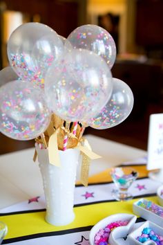 a vase filled with balloons on top of a table