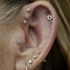 an ear with four different types of piercings on the top and bottom of it