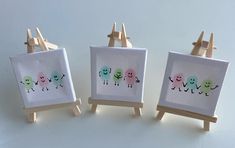 three small wooden easers with embroidered pictures on them