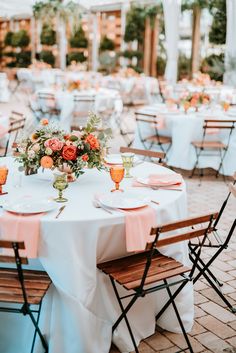 an outdoor wedding reception set up with tables and chairs