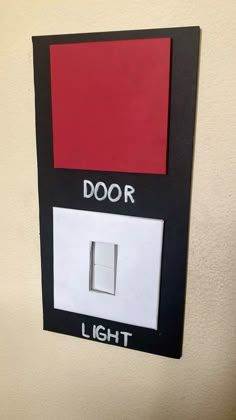 a light switch with the word door painted on it and a red square in the middle