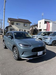 a grey car parked in front of some buildings and cars on the street with other vehicles behind it