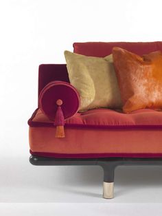 an orange and red couch with pillows on it