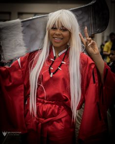 a woman with long white hair wearing a red robe