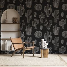 a chair and table in front of a black wall with cactus designs on the walls