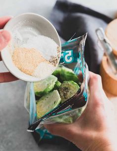 someone is holding a measuring cup filled with sugar and other ingredients to make a snack