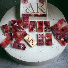 red and gold dices sitting on top of a white table next to a box