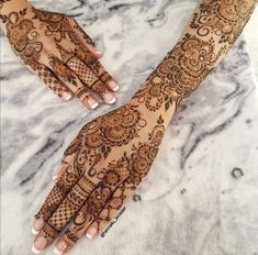 two hands with henna designs on them