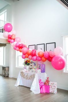 a table with pink and orange balloons on it