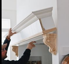 a man is working on a window sill in his home with wood trimming