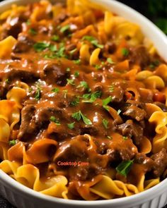 a white bowl filled with pasta covered in beef and cheese sauce, garnished with parsley