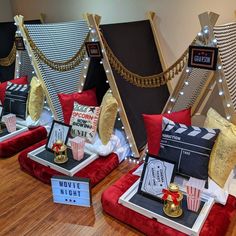 several movie themed pillows and decorations on display in a room with wooden floors, red velvet couches and gold trimmings