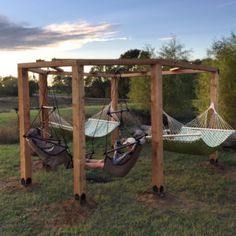 two people sitting in hammocks on the grass