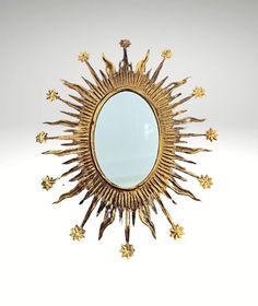 a mirror that is sitting on top of a white surface with gold stars around it