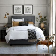 a bedroom with two framed pictures above the bed