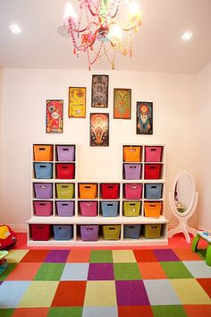 the room has many colorful bins on the wall and a chandelier hanging from the ceiling