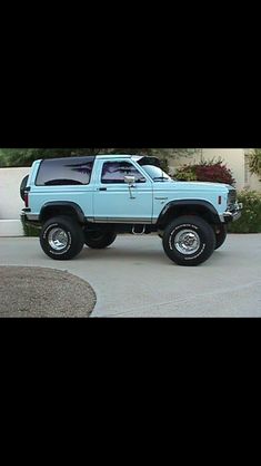 a blue pick up truck parked in front of a house