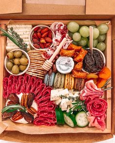 a wooden box filled with different types of meats, cheeses and crackers