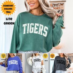 "Unleash the Spirit with Our Custom Tigers Mascot Comfort Colors Sweatshirt." This sweatshirt brings school pride and team spirit to a whole new level. With our custom mascot design, you can proudly represent your school or organization wherever you go. Made with the finest Comfort Colors fabric, it offers unparalleled comfort and durability. Whether you're cheering from the stands, on the field, or simply hanging out with friends, this sweatshirt is your ultimate go-to for coziness and style. S Green Letter Print Top For College, Casual Tops With Lettering For Campus, Casual Campus Tops With Lettering, Green Letter Print Tops For Game Day, Green Tops With Letter Print For Game Day, Green Sporty Tops For Campus, Sporty Green Tops For Campus, Green Casual Sweatshirt For School, Green School Spirit Top