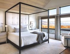 a bedroom with a four poster bed and white furniture