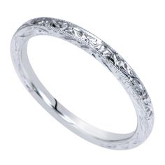 a wedding band with intricate engraving on the sides and an engraved design in the middle