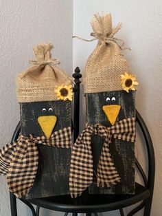 two black birds with sunflowers on their heads are sitting in front of a door