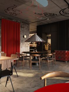 a room with chairs, tables and a lamp hanging from the ceiling in front of a red curtain