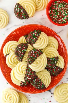 some cookies are on a red plate with sprinkles