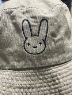 Bad Bunny logo bunny Bucket Hats para el verano!! The bucket hats have a nice feel to them as they are cotton.  Great for a sunny day! Fits most men and women.  Handmade to order embroidered bucket hats with string cords. I can customize the embroidered thread to whatever color you'd like ! MEASUREMENTS: S/M Fits a size 20-22 inch head L/XL  Fits a size 22 1/2 - 24 inch head  *REFUND & RETURN POLICY: * These hats are made to order, All sales are final. No exchanges. If you have any questions or concerns, feel free to message us!! Thank you Bunny Bucket Hat, Bad Bunny Logo, Bucket Hat With String, Day Fits, Embroidered Bucket Hat, Bunny Logo, Dad Caps, Bad Bunny, Bucket Hats